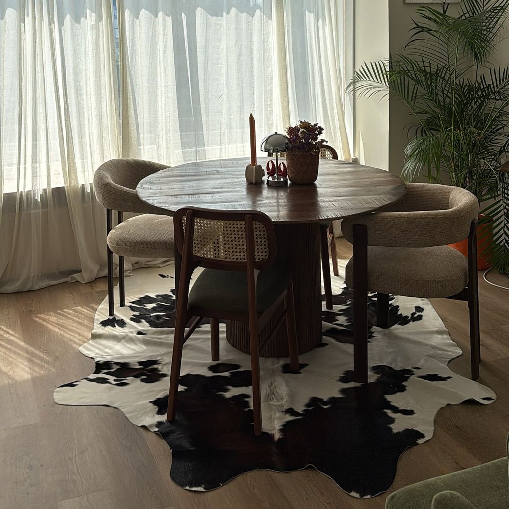 Tapis en peau de vache noir et blanc d'une cliente sous une table ronde